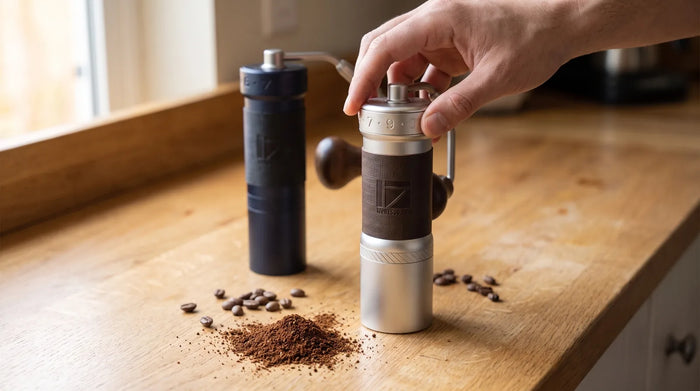 Hand stellt den Zahlenring der 1Zpresso K-Ultra Handmühle ein, dahinter die 1Zpresso ZP6 Special