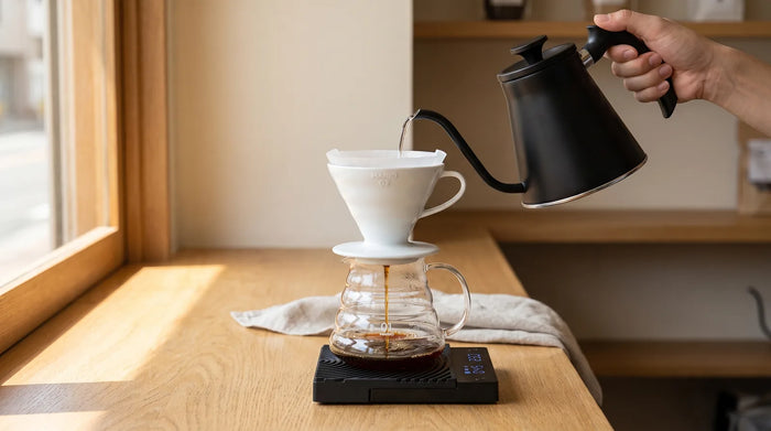 Wasser aus dem Hario V60 Fit Kessel wird in den Hario V60 Keramik-Dripper auf dem Range Server und der Timemore Mirror Mini gegossen