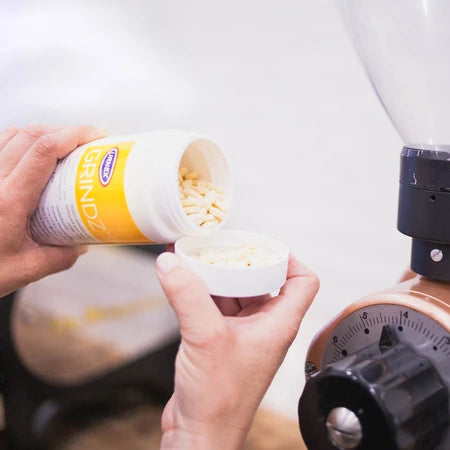 Granulat aus der Grindz-Dose in den Dosierbecher einer Kaffeemühle füllen